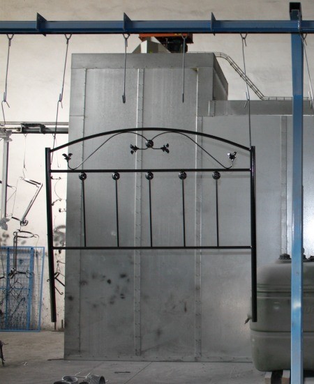 Cómo se fabrica un cabecero de forja, paso a paso en el taller 16 Cabecero de forja negro terminado apoyado en la pared del taller