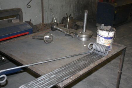 Cómo se fabrica un cabecero de forja, paso a paso en el taller 2 Barras de hierro macizo y herramientas sobre la mesa del taller