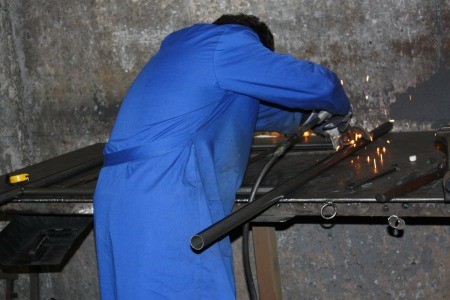 Cómo se fabrica un cabecero de forja, paso a paso en el taller 10 Soldador del taller de Forja Hispalense uniendo las piezas de un cabecero